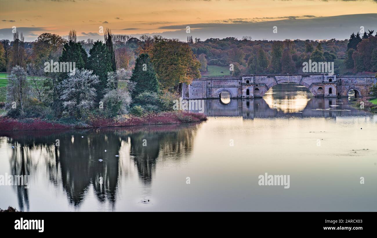 Eine Landschaft, die zur Dämmerung gedreht wurde und eine alte Brücke in der Nähe des Blenheimer Palastes zeigt, eine schöne Landschaft und ein Gefühl von Ruhe und Frieden bei dieser Aufnahme Stockfoto
