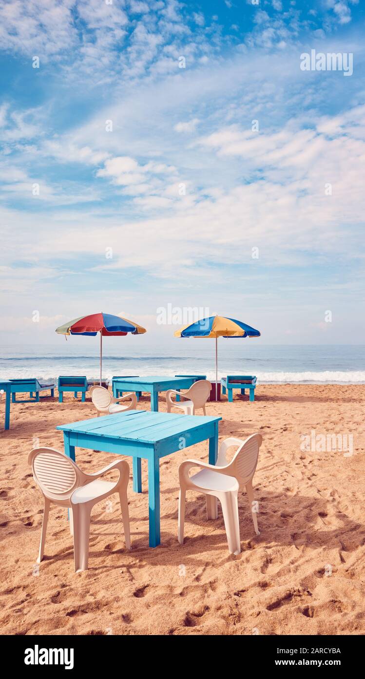 Tische und Stühle an einem tropischen Strand, Sommerferienkonzept, Farbtonierung angewendet, Sri Lanka. Stockfoto