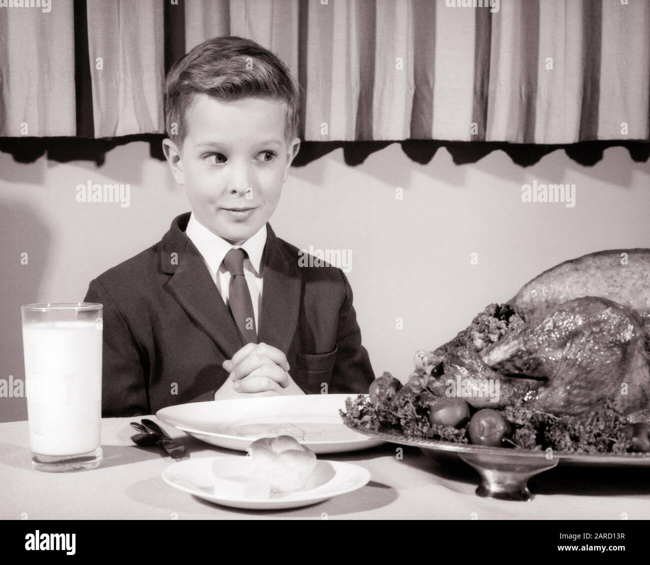 FÜNFZIGER JAHRE DER 1960ER JAHRE JUNGE MIT ANZUG UND KRAWATTE SITZEND AN DEN TISCHHÄNDEN KLAFFTE SPRUCH ANMUT SCHAUEND UNHEIMLICH AUF GROSSEM THANKSGIVING TÜRKEI - F972 HAR001 HARS JUGENDLICHE MIMIK COMIC FREUDE LEBENSSTIL ZUFRIEDENHEIT RELIGION CELEBRATION STUDIO SCHOSS GESUNDHEIT SAYING HOME LIFE DAIRY COPY SPACE HALBLÄNGE MÄNNER GRACE AMERICANA AUSDRÜCKE B&W ANZUG UND KRAWATTE HUMORVOLLE HUNGRIGE GLÜCKSSTRATEGIE UND SPANNUNG FLUID KOMISCHE RICHTUNG ERWARTUNG DANKBARE VERBINDUNG DONNERSTAG KONZEPT GEKLEMMT COMEDY NATIONALFEIERTAG DANKBARE ZUSAMMENARBEIT DINNER ROLL GROWTH JUNGES NOVEMBER GEFLÜGEL PROTEIN TISCH EINSTELLUNG Stockfoto