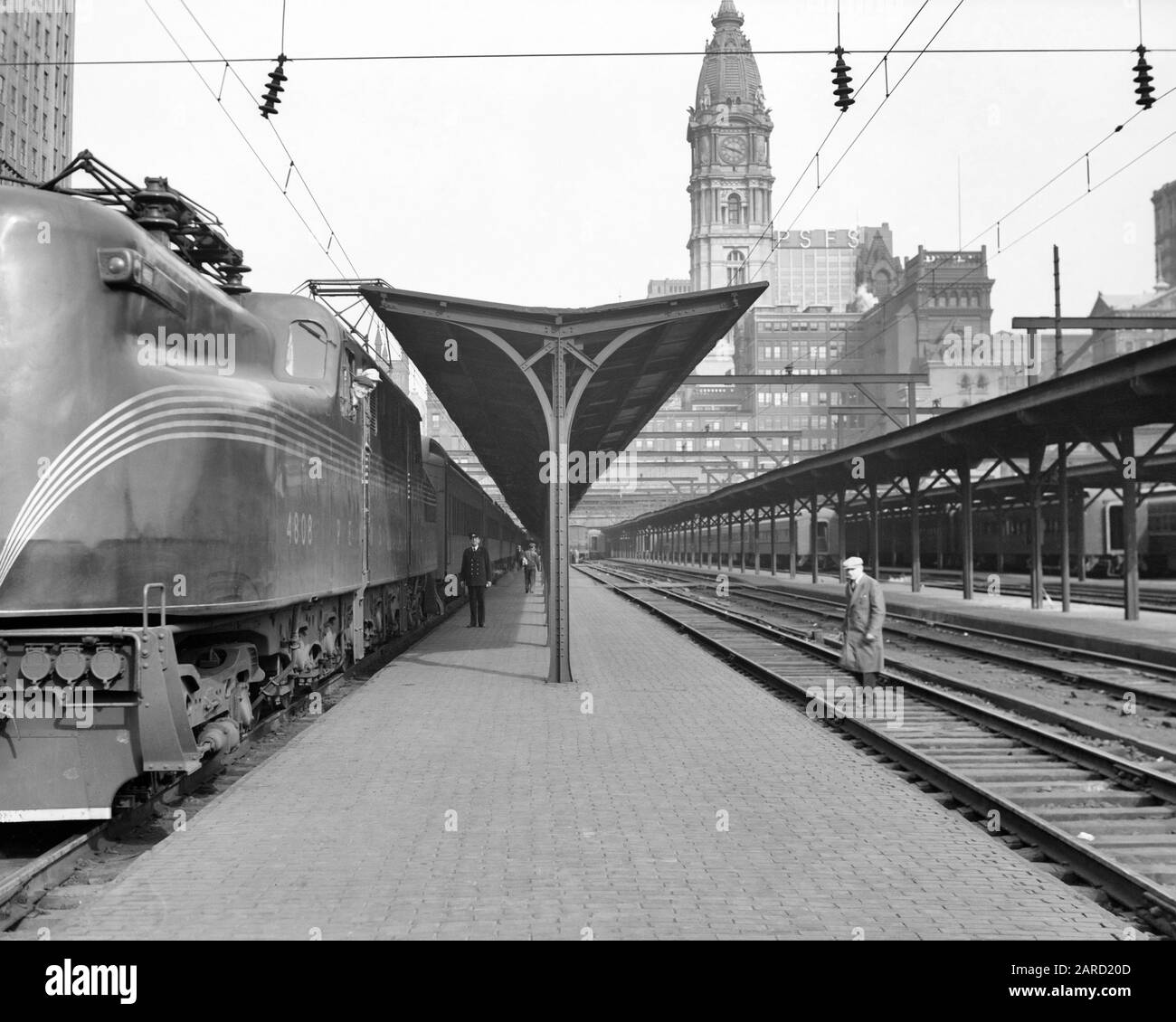 1930ER JAHRE PENNSYLVANIA EISENBAHN GG-1 ELEKTROLOKOMOTIVE IN DER STADT VORORTSTATION PHILADELPHIA PENNSYLVANIA USA - Q41874 CPC001 HARS VEREINIGTE STAATEN KOPIEREN RAUM PERSONEN VOLLER LÄNGE VEREINIGTE STAATEN VON AMERIKA MÄNNER TRANSPORT B&W NORDAMERIKA NORDAMERIKA EISENBAHN-GESCHICKLICHKEIT BESATZUNGSPLATTFORM FÄHIGKEITEN STADT HALLE KUNDENSERVICE ÄUSSERE PA LEISTUNGSSTARKE PROGRESS-LOKS BERUFE NORTHEASTERN COMMONWEALTH CONNECTION CITIES KEYSTONE STATE STYLISCHE EISENBAHNEN ANONYMOUS GENERAL ELECTRIC PRR 1934 SCHWARZ-WEISSE STADT DER BRÜDERLICHEN LIEBE PENDLER ALTMODISCH Stockfoto