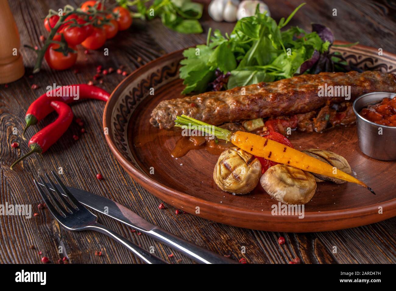 Türkisch und Arabisch Traditioneller Ramadan mischen Kebabplatte, Kebab-Rind mit gebackenem Gemüse, Pilzen und Tomatensauce auf Holzgrund, Horizontal Stockfoto