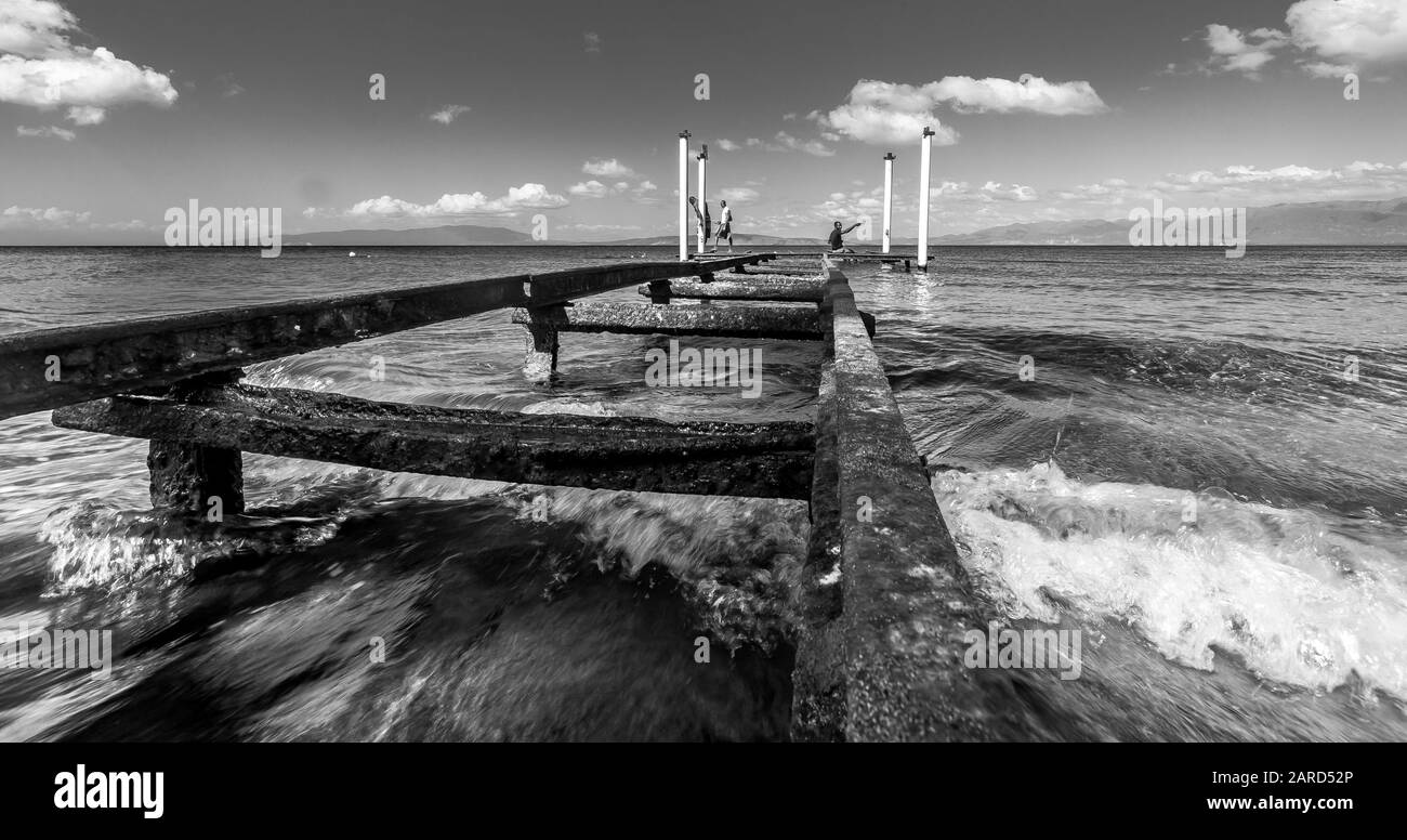 Dramatisches Bild des alten verrosteten Piers an der karibischen Küste mit Aqua-Blau-Wasser, das zum Angeln verwendet wird. Stockfoto