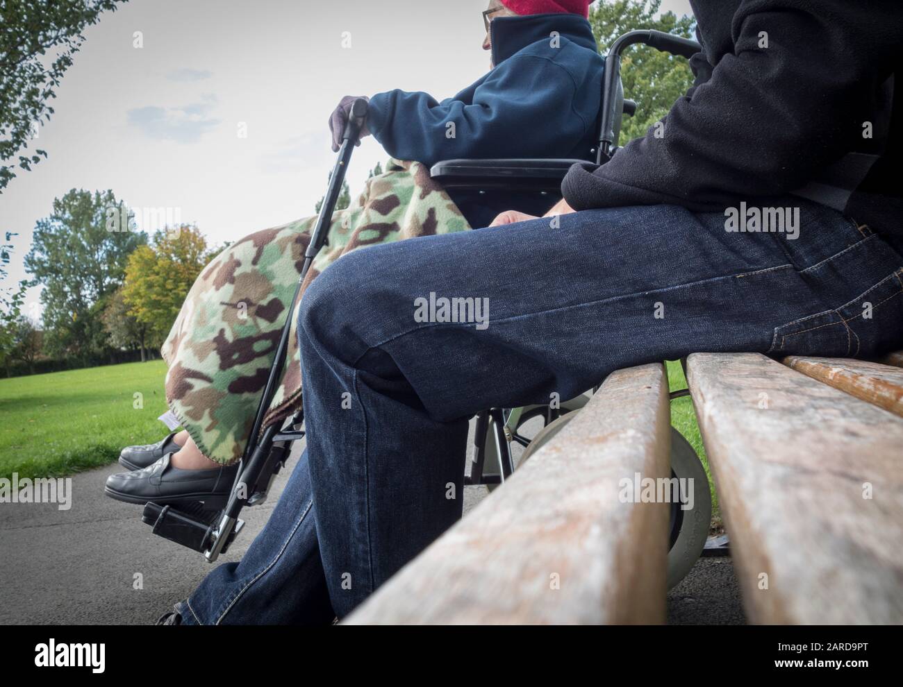 Betreuungsperson (Sohn) mit dem 90 Jahre alten Mutter im Rollstuhl in den öffentlichen Park. Großbritannien Stockfoto