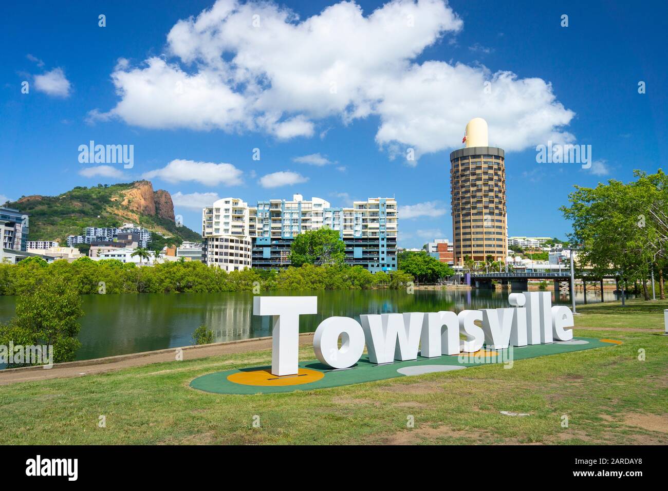 Schild Townsville am Ufer des Ross River mit der Skyline der Stadt und dem Castle Hill im Hintergrund. Central Park, Townsville Queensland. Stockfoto