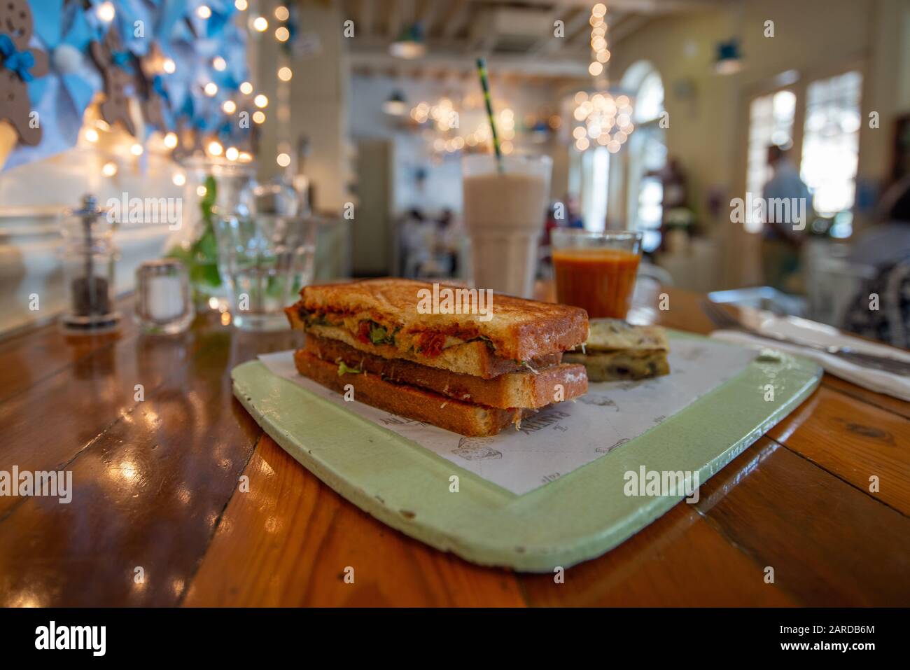 Ein schmackhaftes Sandwich auf einer bemalten Tafel in einem nicht erkennbaren Restaurant mit verschwommenem Hintergrund Stockfoto