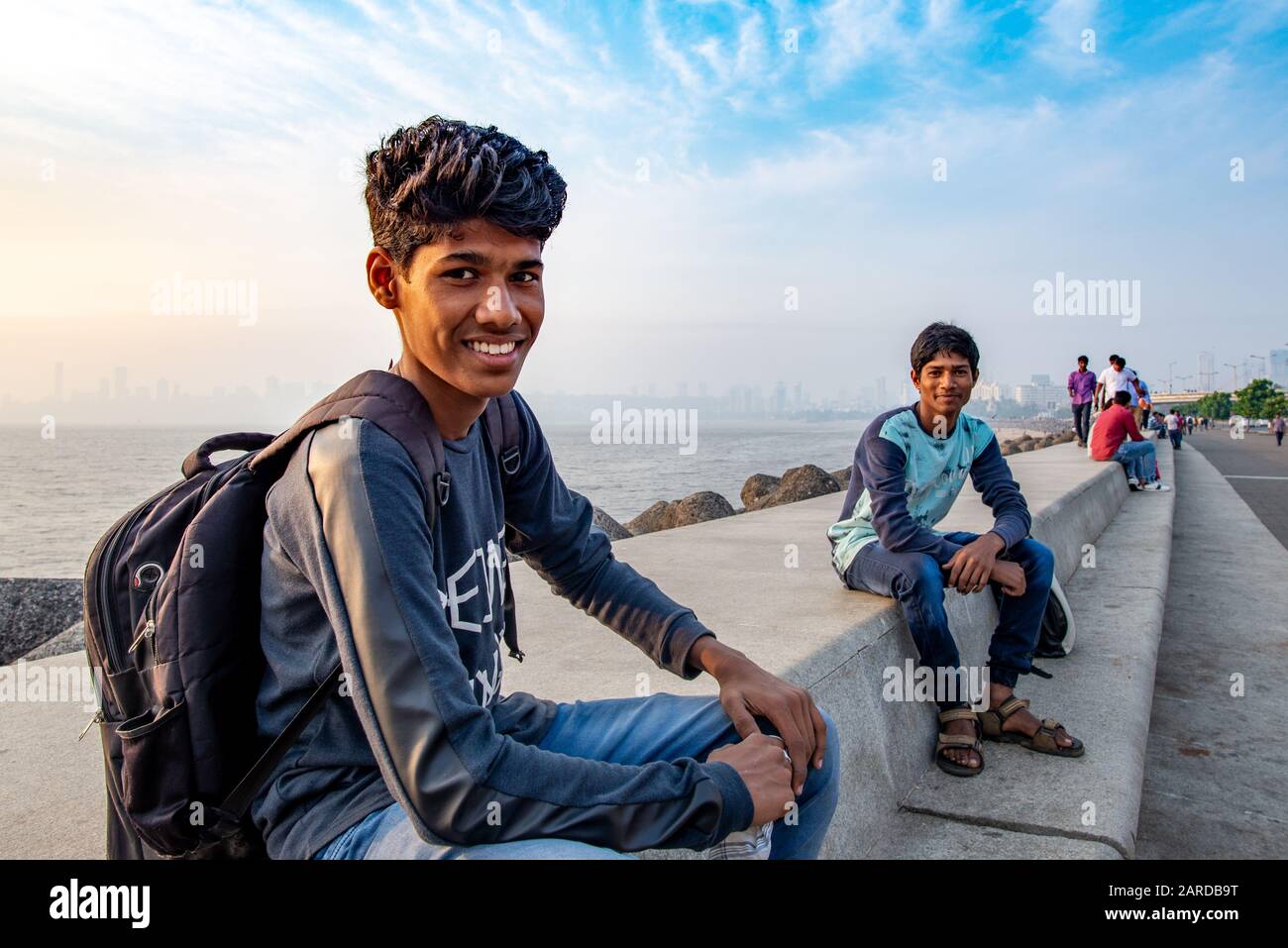 Mumbai, Indien - 15. Dezember 2017: Junge indische Männer, die am Ende des Nachmittags in der Kamera auf Marine Drive posieren Stockfoto