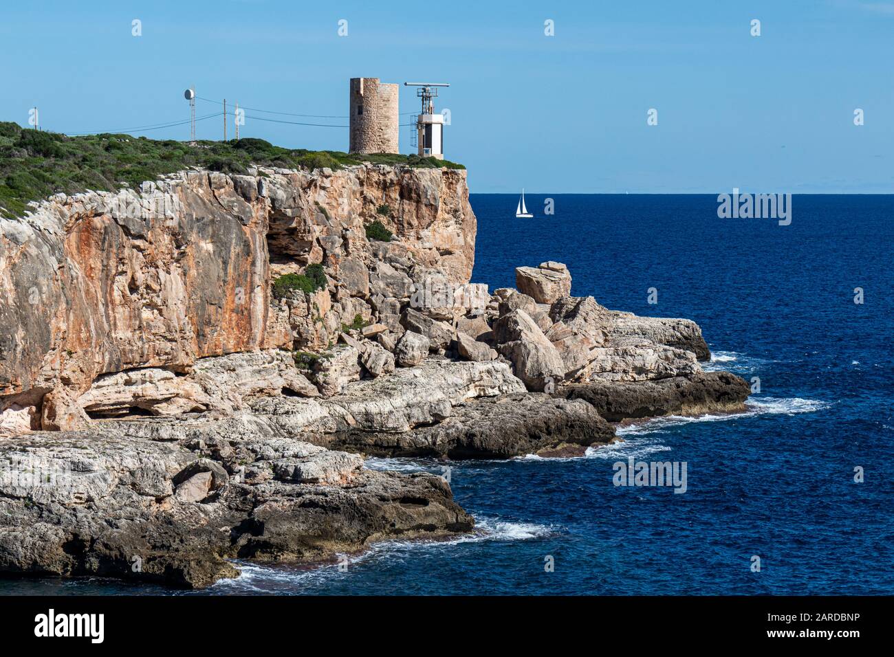 Der alte Wachturm Torre d'en Beu, auch Torre de Cala Figuera, neben dem kleinen Leuchtturm auf einer Klippe in Cala Figuera, Mallorca, Balearen, Spanien Stockfoto