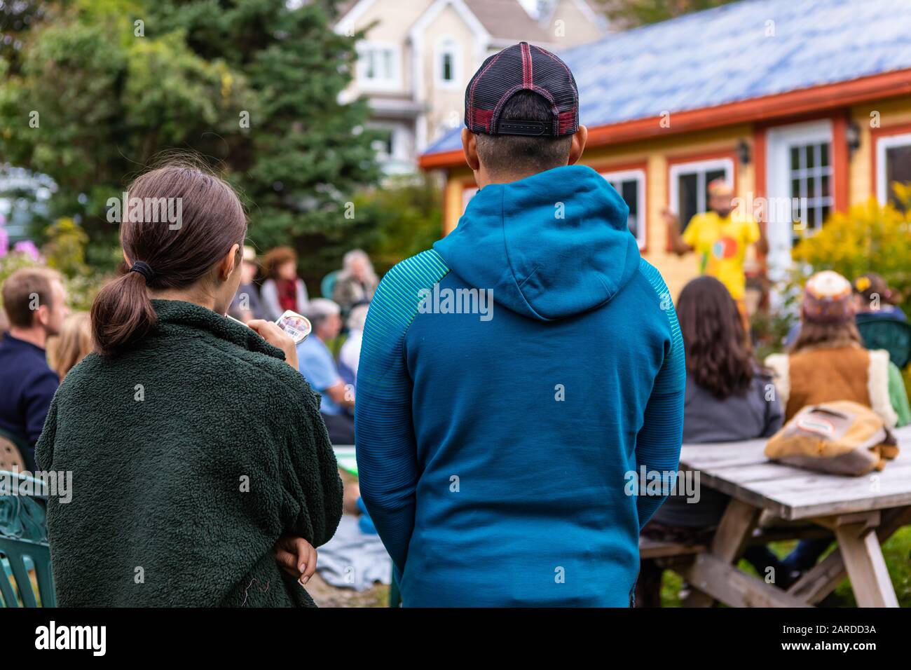 Rückansicht von Bruder und Schwester, die Pullover und Hoodie tragen, während sie stehen und Märchengeschichte in der Welt und Spoken Word Festival genießen Stockfoto