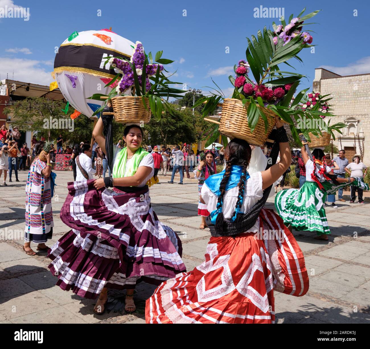 Frau tanzt in fließenden traditionellen Outfit mit Blumenkorb Teil der traditionellen Parade (Calenda de Bodas) auf den Straßen von Oaxaca. Stockfoto