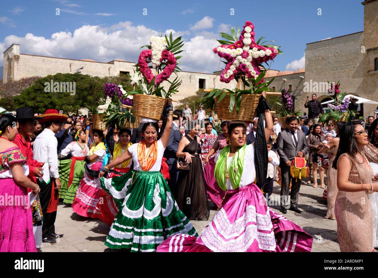 Frau tanzt in fließendem traditionellen Outfit mit Blumenkorb Teil der Traditionellen Hochzeitsfeier (Calenda de Bodas) auf den Straßen von Oaxaca. Stockfoto