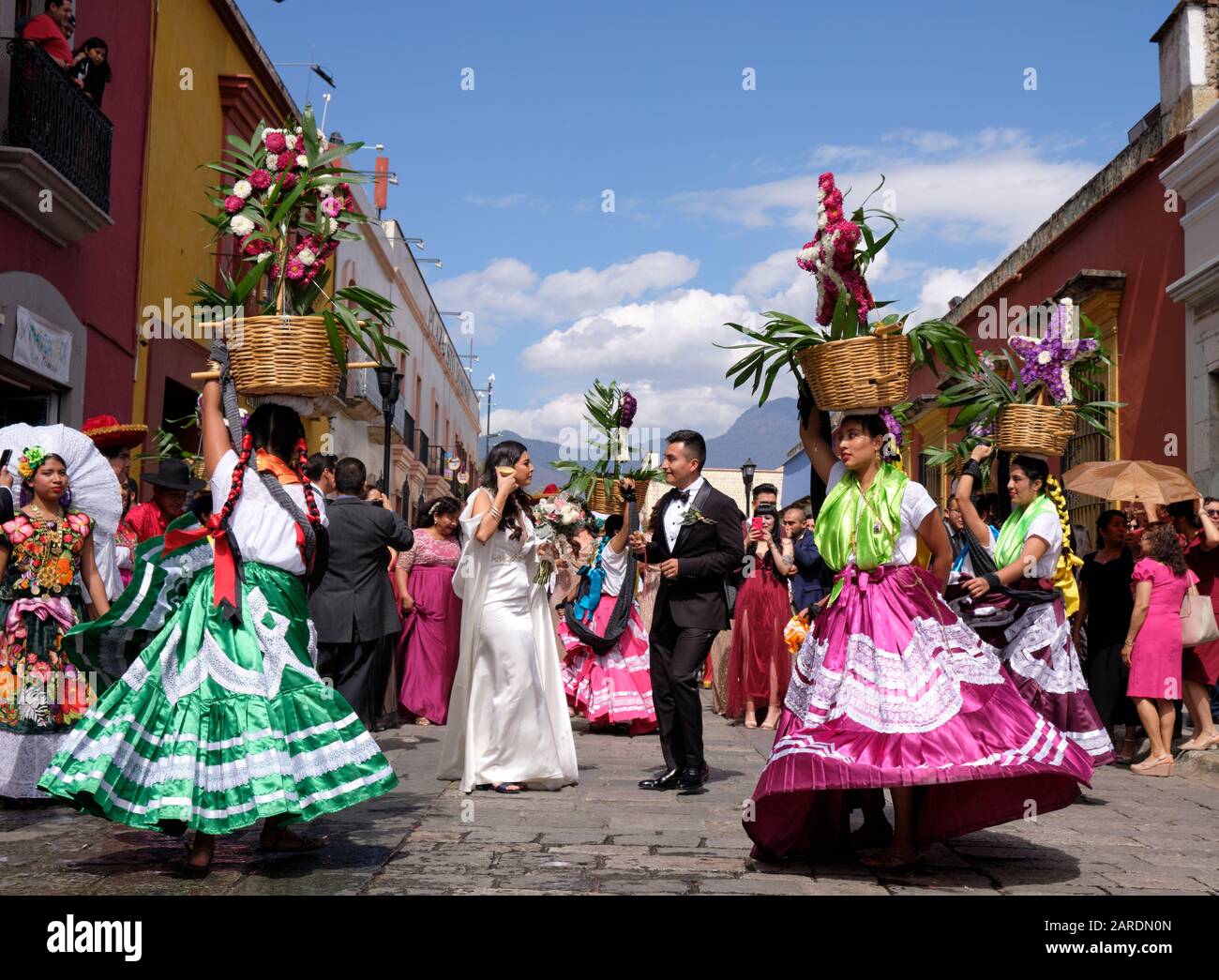 Brautpaar gerahmt von Frau im traditionellen Outfit Teil der Traditionellen Hochzeitsfeier (Calenda de Bodas) auf den Straßen von Oaxaca. Stockfoto