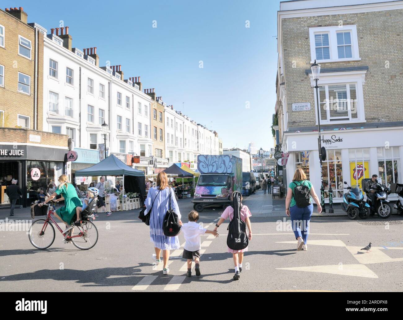 Mutter und Kinder, die Hände über eine Straße halten, Portobello Road, Notting Hill, West London, England, Großbritannien Stockfoto