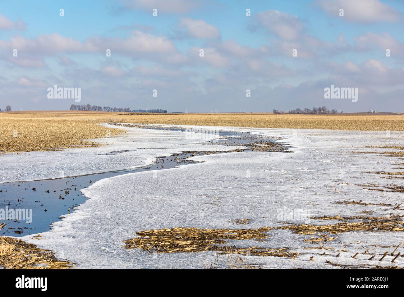 Bauernfeld nach starken Winterregen stürmt mit Wasser, das sich auf Eis dreht, wenn die Temperatur unter das Gefrierpunkt fällt Stockfoto