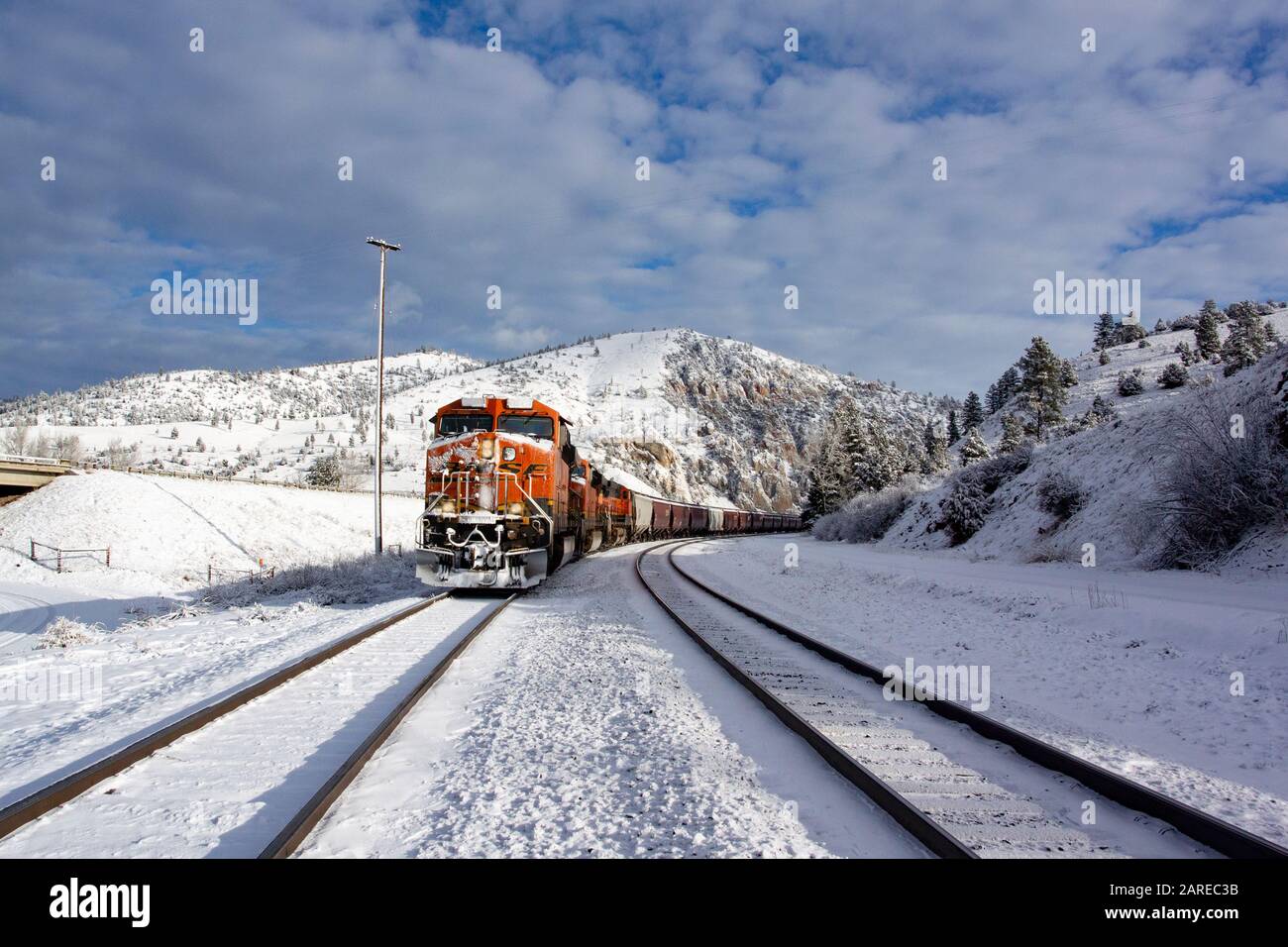 Ein BNSF train Kommen hinunter die Spuren im Schnee An einem kalten, hellen, sonnigen Tag. Bei Bearmouth, westlich von Drummond, Montana in Granit County. Stockfoto