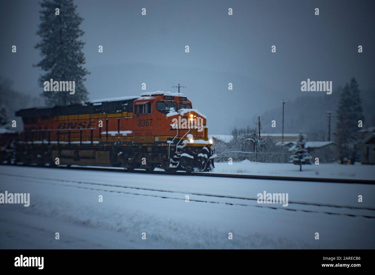 Ein BNSF-Zug, der an einem kalten Wintermorgen in die Stadt Troy, Montana kommt. Stockfoto