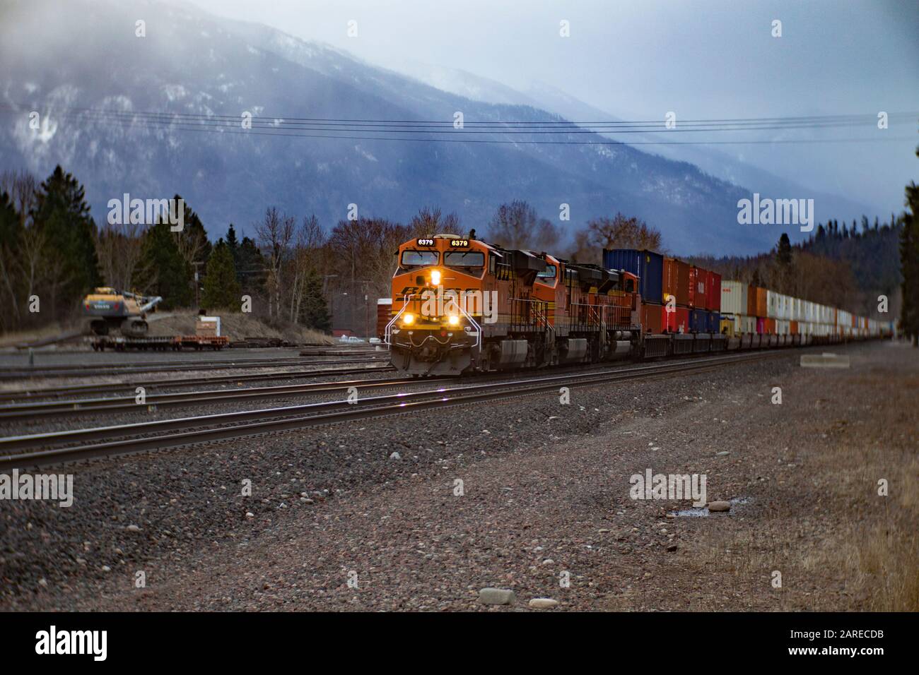 Ein BNSF train unten kommen die Tracks in die Stadt Troja, Montana Stockfoto