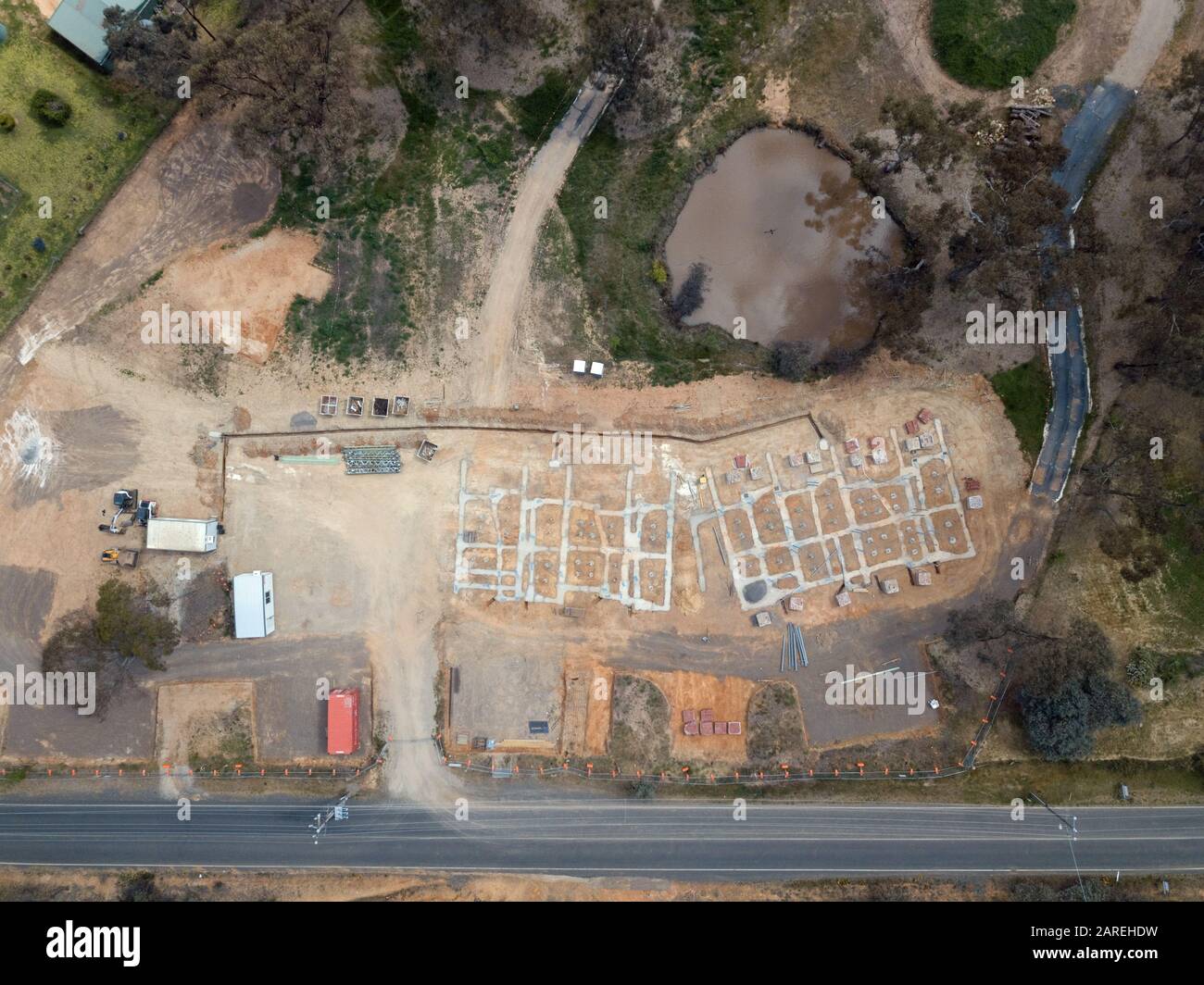 Unterteilung Häuser und geplante Öko-Wohnbau Entwicklung Luftbild mit Betonschalung, Bäume und Asphaltstraße in Victoria, Australien. Stockfoto