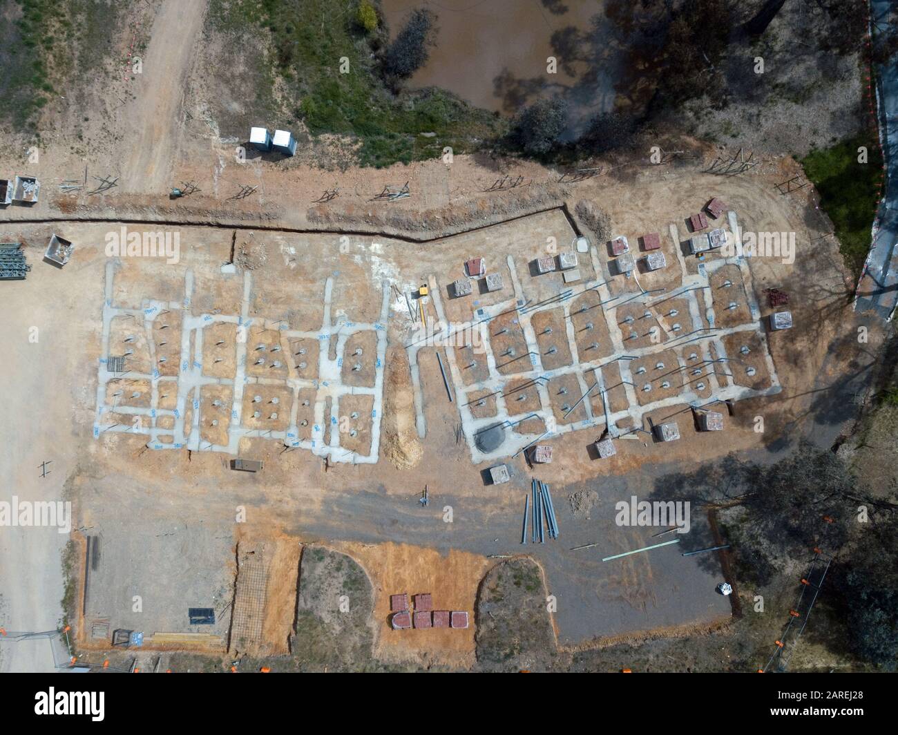 Unterteilung Häuser und geplante Öko-Wohnbau Entwicklung Luftbild mit Betonschalung, Bäume und Asphaltstraße in Victoria, Australien. Stockfoto