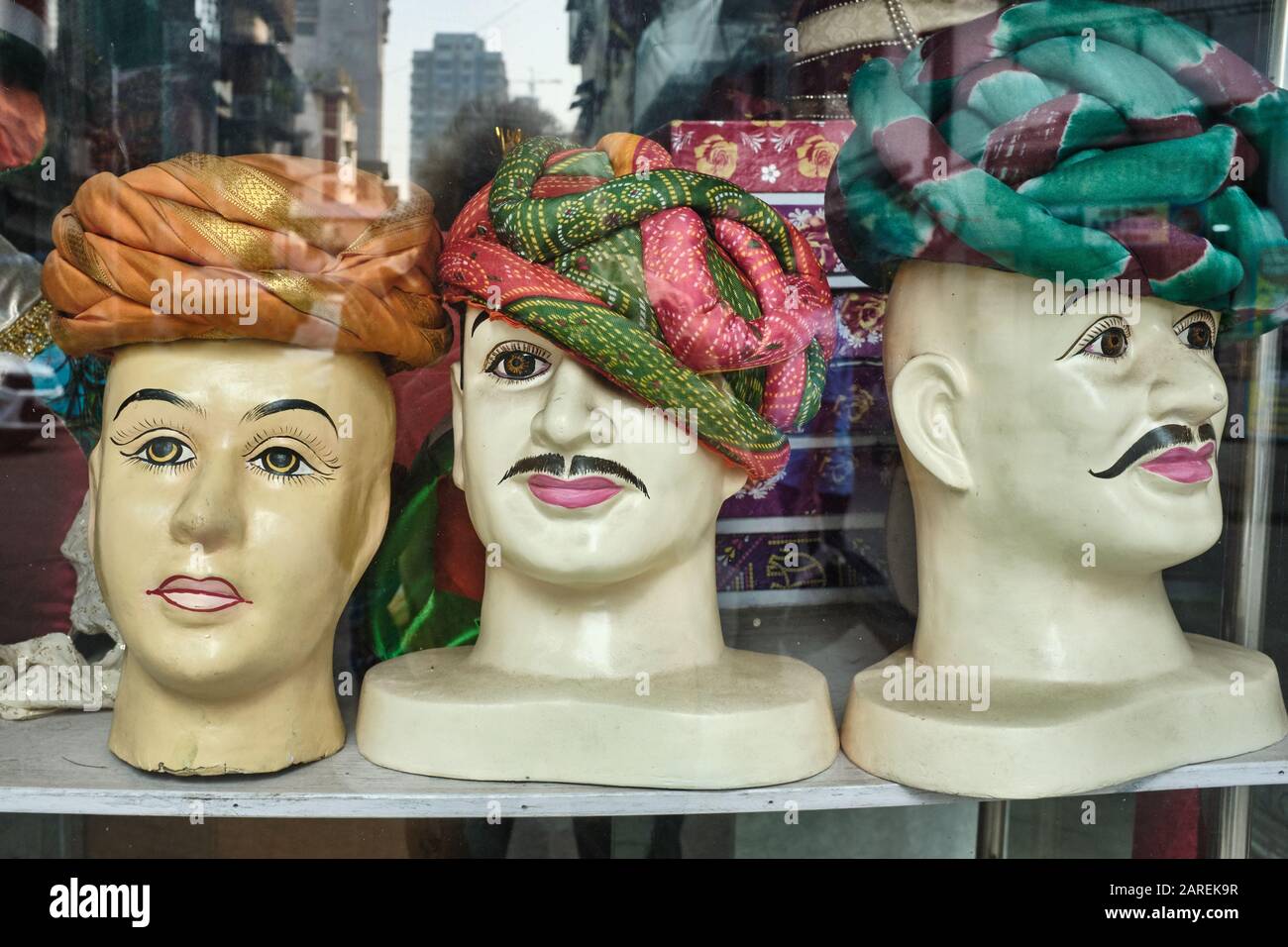 Drei männliche, teils muffige Mannequinsköpfe in einem Schaufenster eines Schneiders in Mumbai, Indien, mit traditionellen festlichen Turbanen aufgesetzt Stockfoto