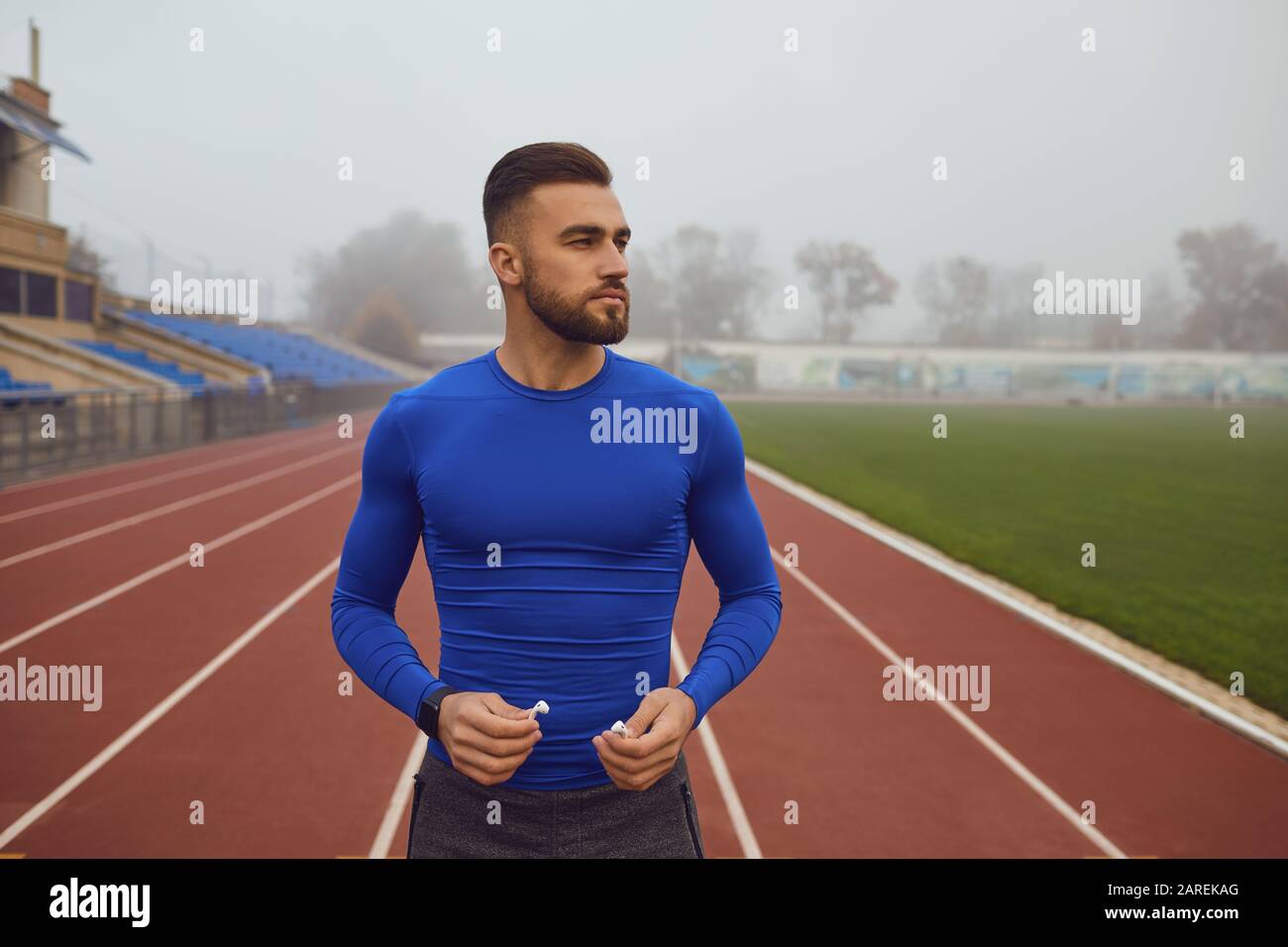 Sport Kerl mit Bart am Stadion am Morgen im Nebel. Stockfoto