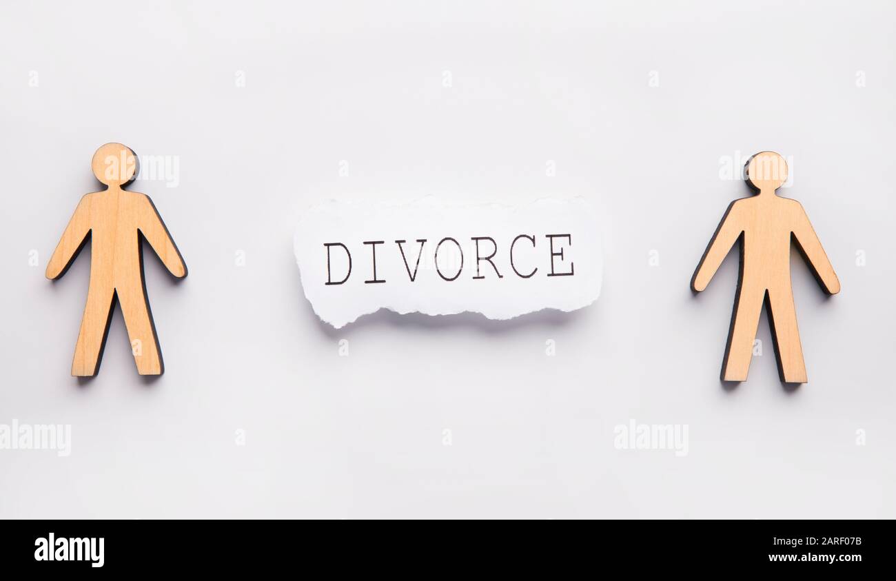 Holzfamilie, Ehefrau und Ehemann auf grauem Tisch, Scheidungstext Stockfoto