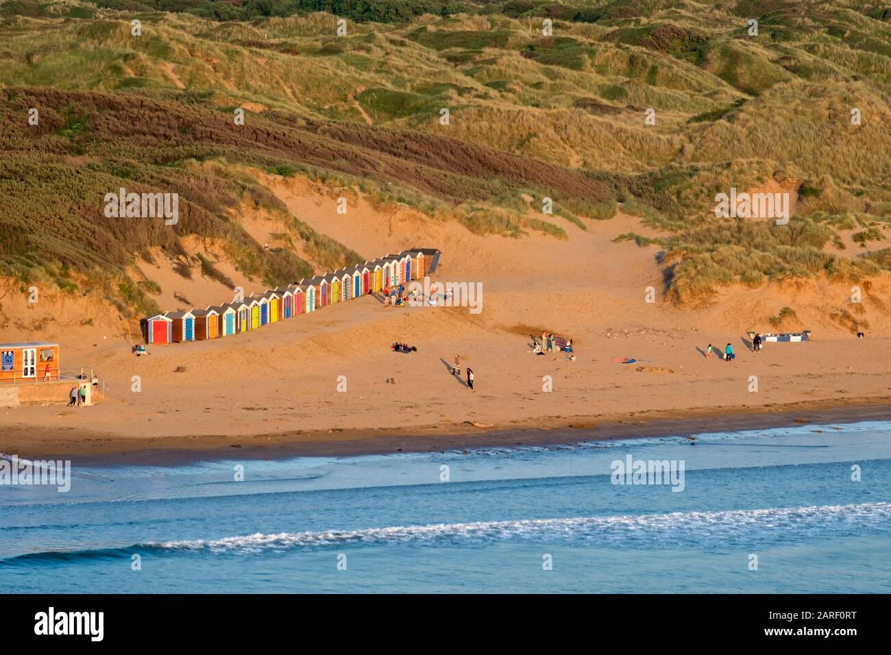 Saunton Sands Strand mit Sanddünen und einer Reihe von bunten, bemalten Strandhütten, Surfen, North Devon South West, Großbritannien Stockfoto