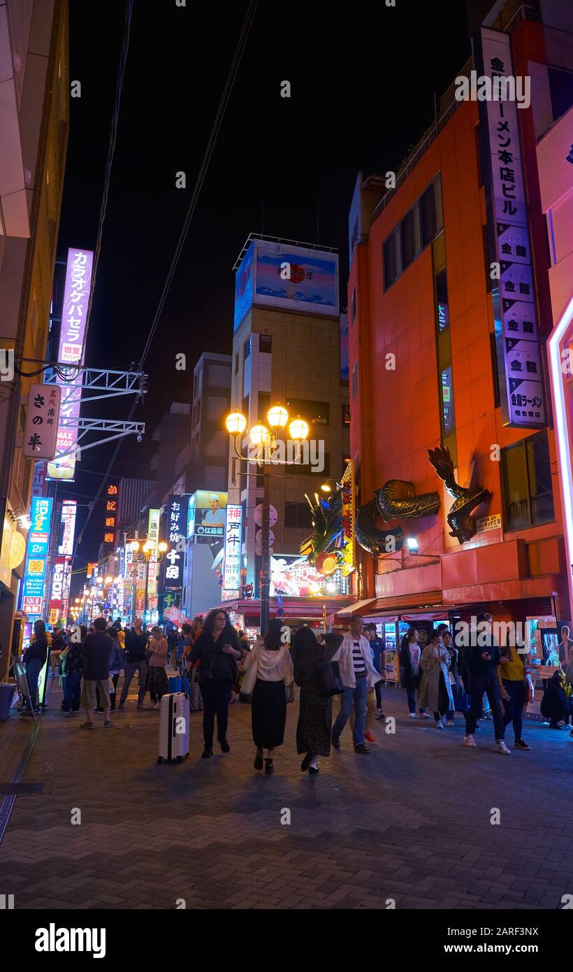 Osaka, JAPAN - 13. OKTOBER 2019: Die nächtliche Aussicht auf Menschen, die die Straße Dotonbori mit Neonlicht, extravaganter Beschilderung und der enormen heruntergehen Stockfoto
