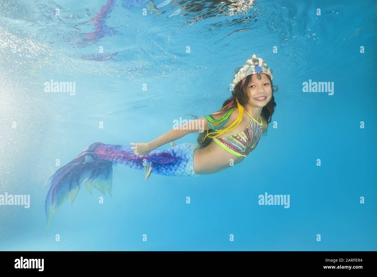 Ein Mädchen in einer Meerjungfrau wirft unter Wasser in einem Pool auf.  Junges, wunderschönes Mädchen stellt sich unter Wasser in den Pool  Stockfotografie - Alamy