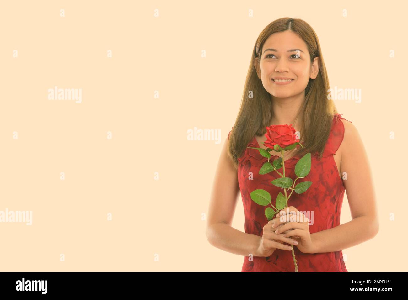 Nachdenklich glückliche junge Frau und lächelnd rote Rose bereit für den Valentinstag Stockfoto