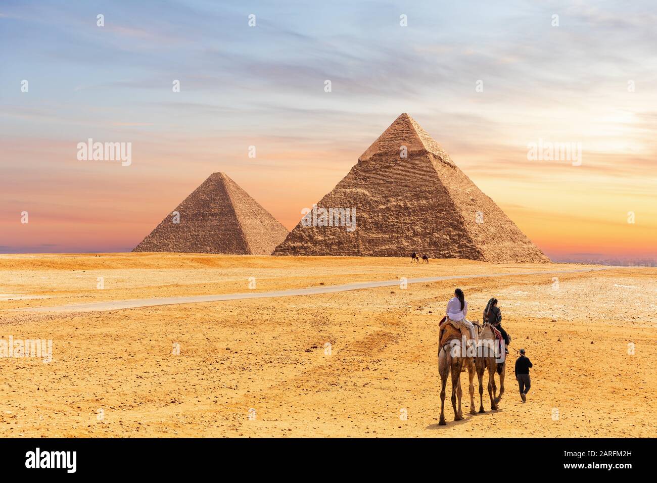 Ägyptische Pyramiden von Gizeh und die Touristen auf einem Kamel. Stockfoto