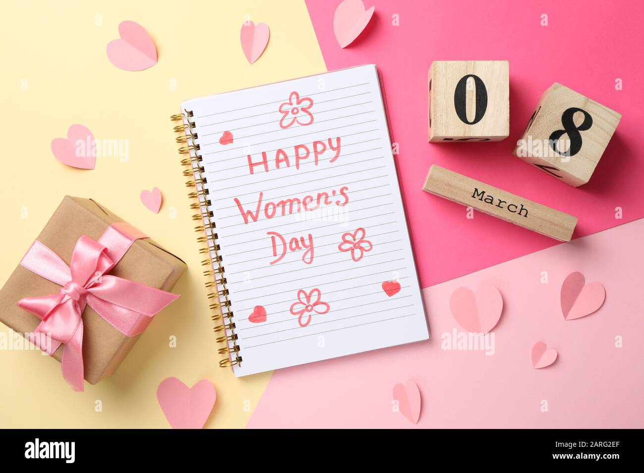 Copybook mit Aufschrift Happy Women's Day auf dekoriertem Hintergrund, Draufsicht Stockfoto