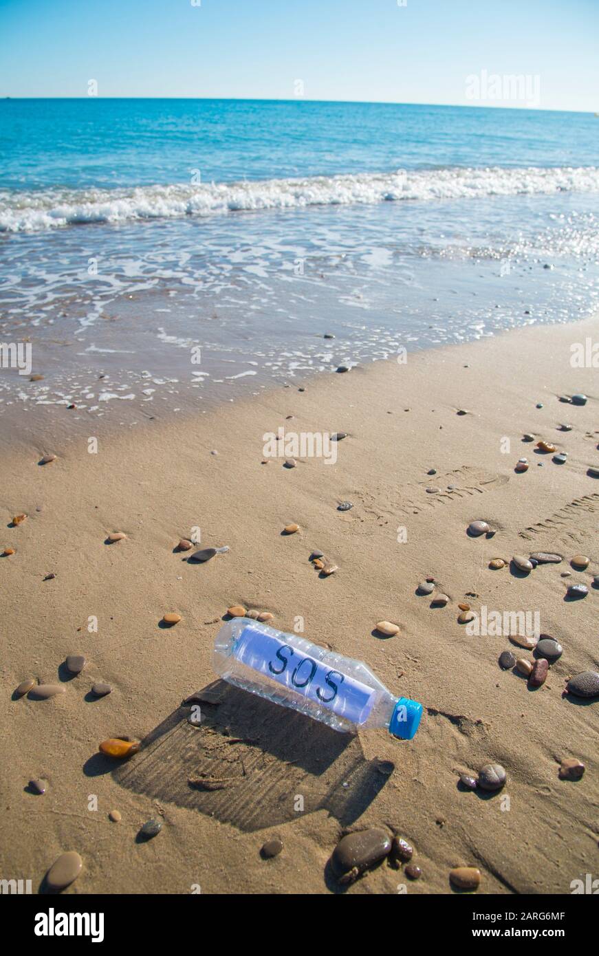 Meer Kunststoff Verunreinigungen. SOS-Nachricht in einer Plastikflasche am Ufer des Meeres. Stockfoto