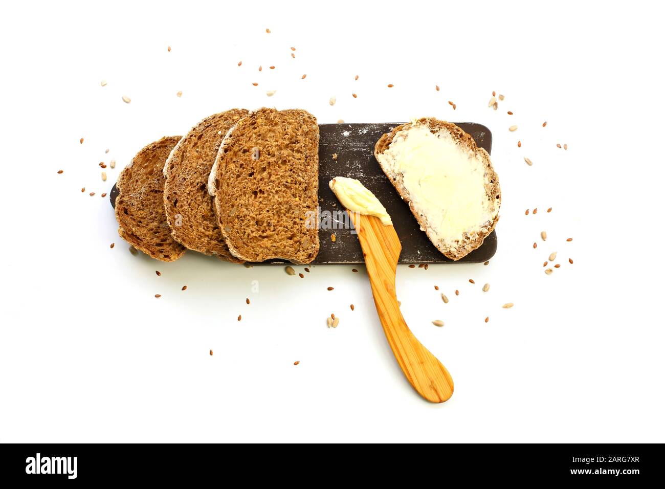 Scheibe Biobrot mit Butter auf Holzschneidebrett isoliert auf weißem Grund. Draufsicht Stockfoto