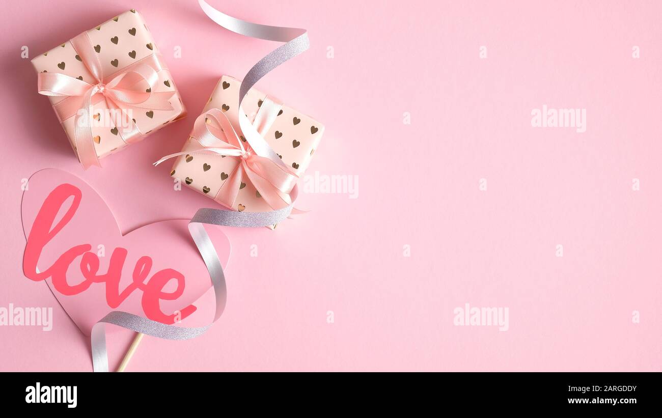 Valentinstag Kartenvorlage mit Geschenken und festlichen Party Requisiten auf pinkfarbenem Hintergrund. Kreatives Design für die Grußkarte zum Valentinstag, Partyeinstieg Stockfoto