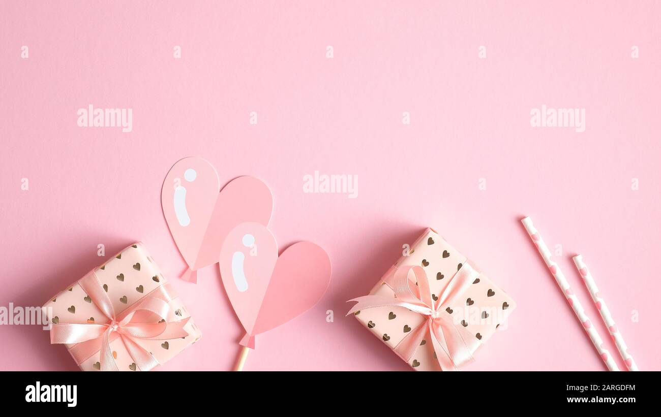 Valentinstag Kartenvorlage mit Geschenken und festlichen Party Requisiten auf pinkfarbenem Hintergrund. Kreatives Design für die Grußkarte zum Valentinstag, Partyeinstieg Stockfoto