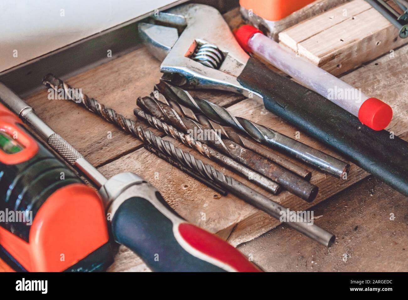 Auf dem Tisch liegen Werkzeuge für die Arbeit mit einem Schraubenschlüssel, einem Schraubendreher und einem Bohrer. Verschiedene Schreinwerkzeuge. Werkzeuge für den Job. Stockfoto