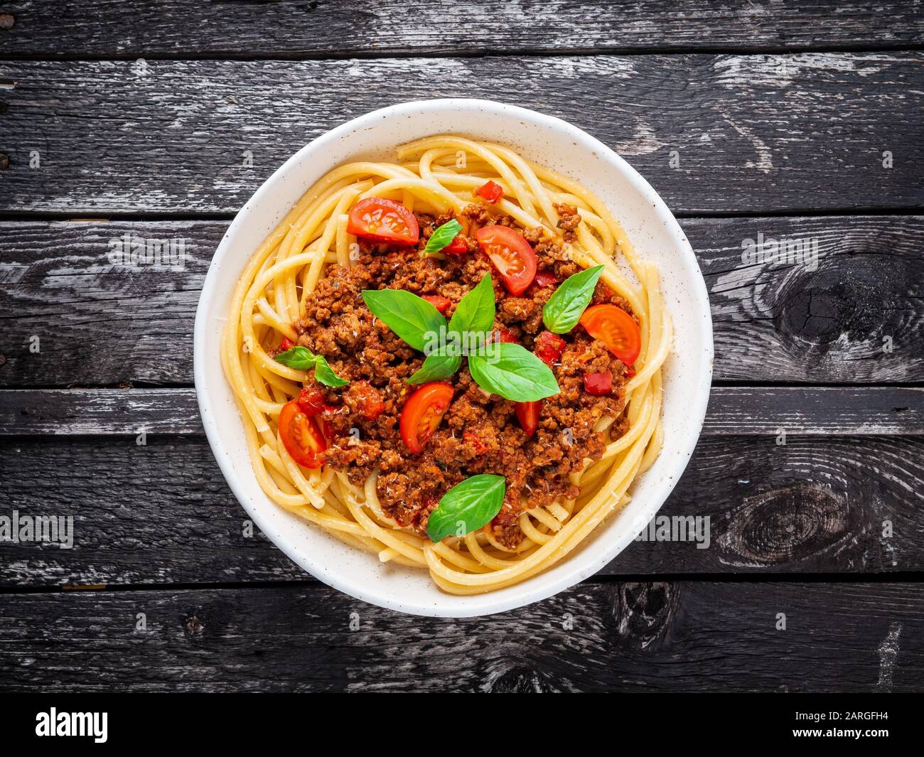 Nudelbolognese mit Tomatensauce, gemahlenes Hackfleisch, Basilikumblätter auf dem Hintergrund Stockfoto