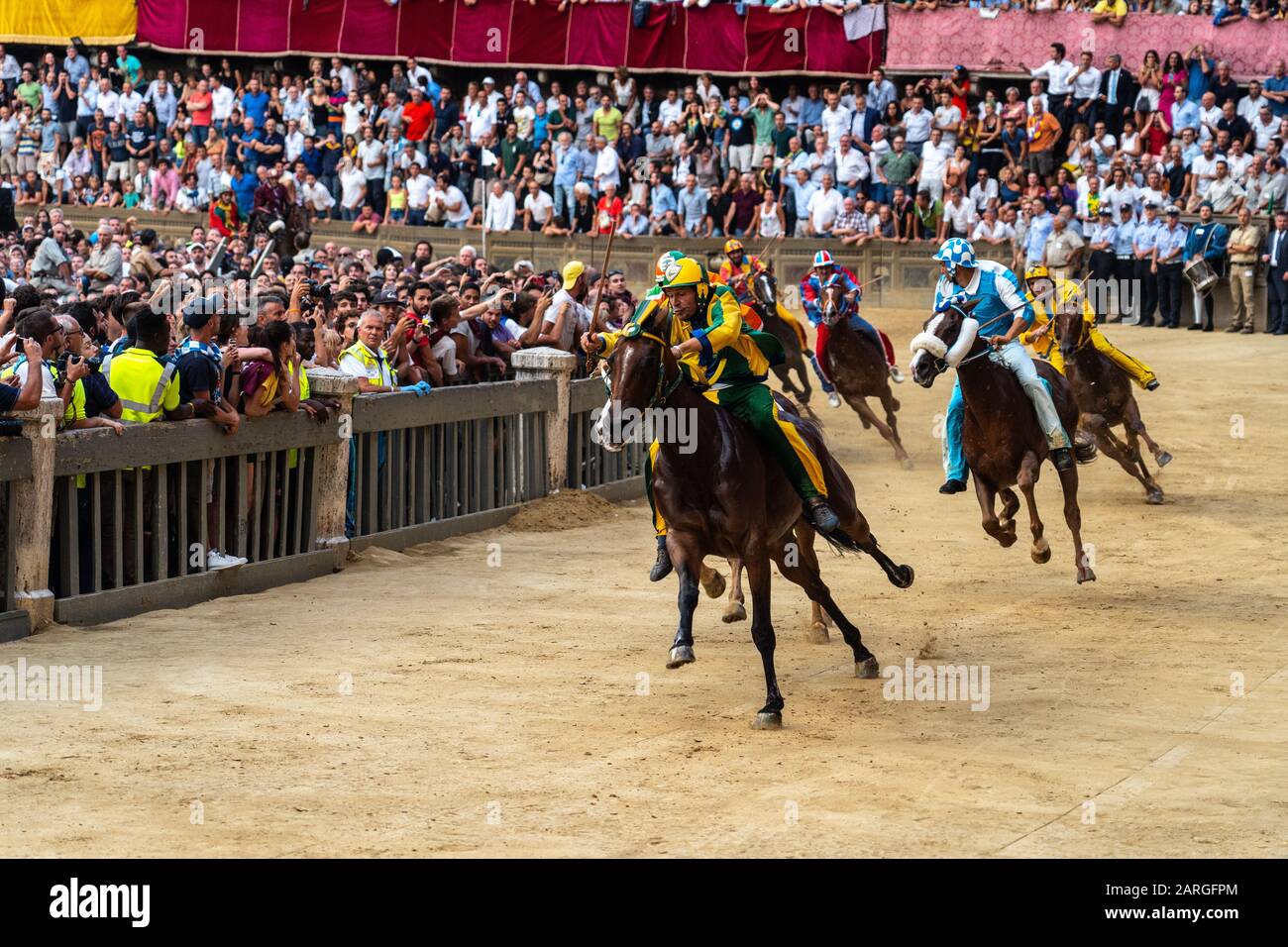 Jockeys in farbenfrohen Outfits, die ihre jeweiligen Wohnviertel am Palio, einer Barebackenhorserei, Siena, Toskana, Italien, repräsentieren Stockfoto