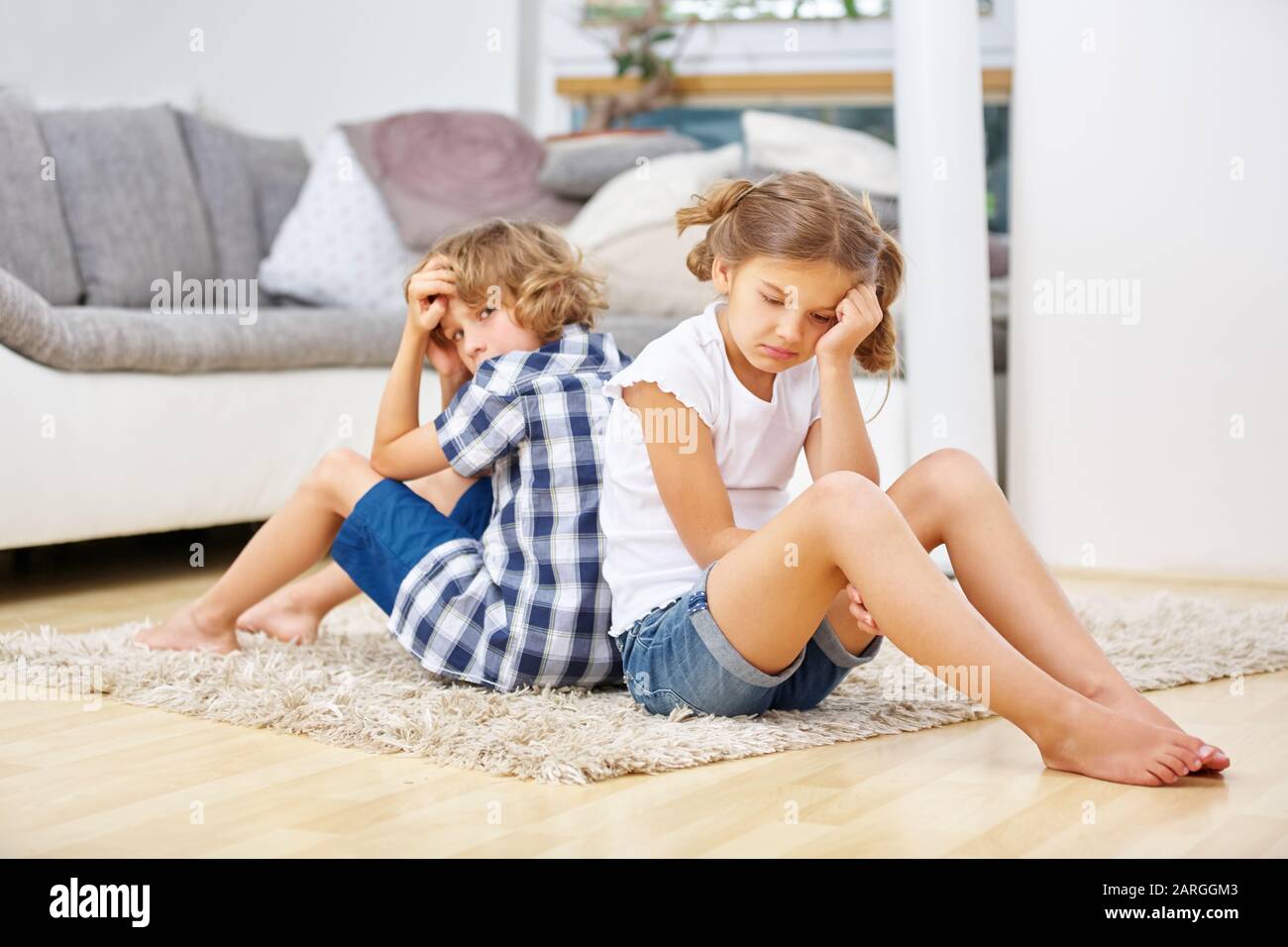 Zwei Geschwister schweigen, nachdem sie sich im Wohnzimmer gestritten haben Stockfoto