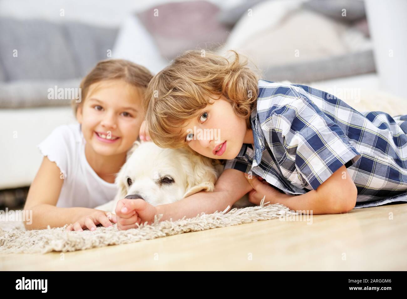 Zwei glückliche Kinder mit goldenem Retriever als Haustier Stockfoto