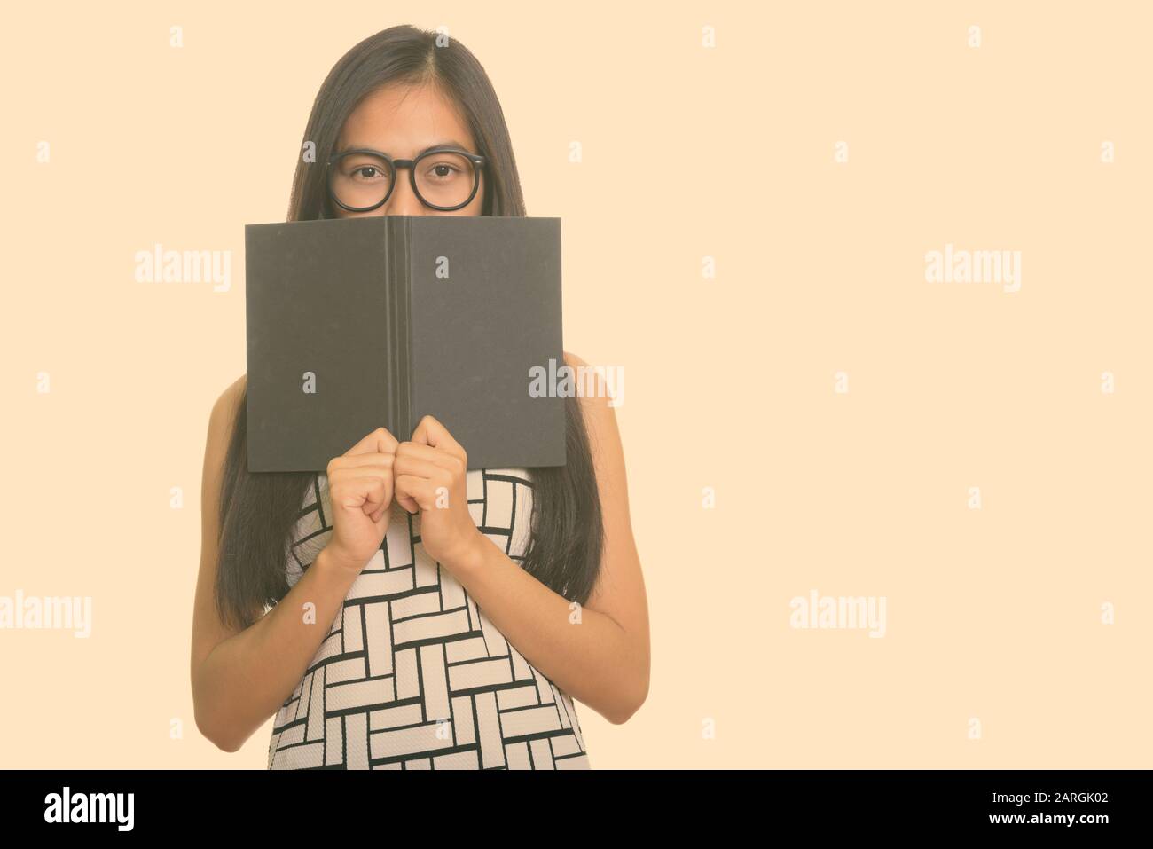 Jungen asiatischen Teenager nerd Mädchen hinter Buch ausblenden Stockfoto