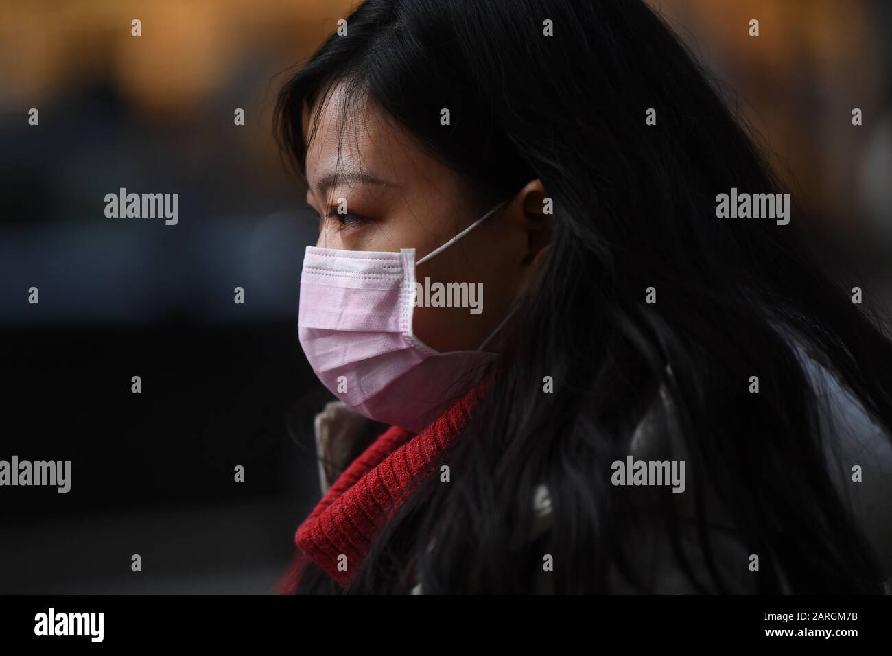 Eine Frau trägt eine Gesichtsmaske, während sie in Holborn, London, Kingsway hinuntergeht. Stockfoto