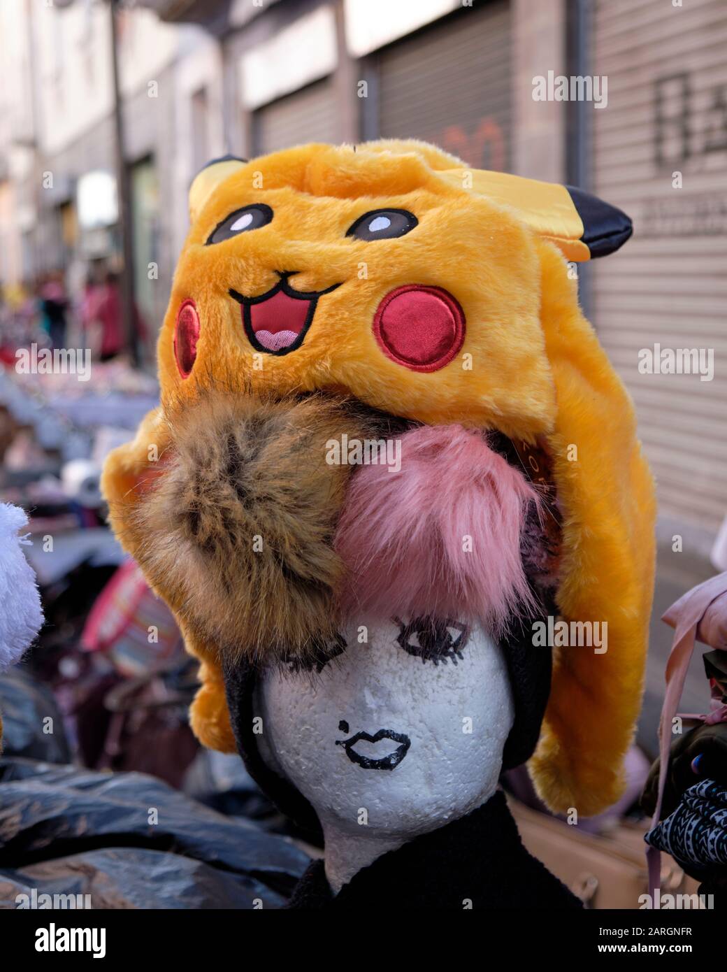 Marktstand mit einem Pikachu-Hut auf einem Styrofoam Mannequinkopf mit eingezogenem Gesicht. Mexiko-Stadt, Mexiko. Stockfoto