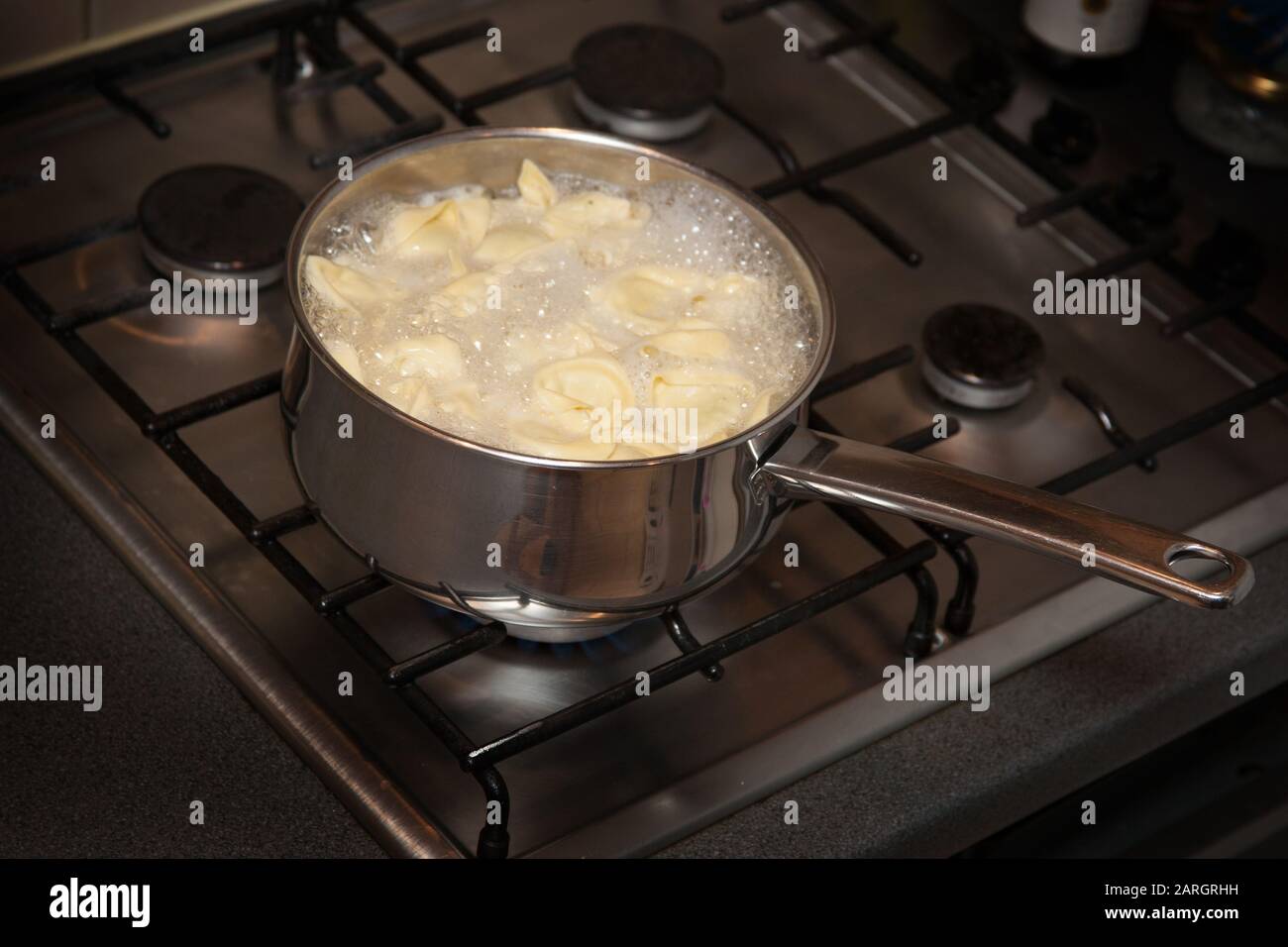 Tortelloni Pasta kochend in Wasser auf einem Kochfeld Stockfoto