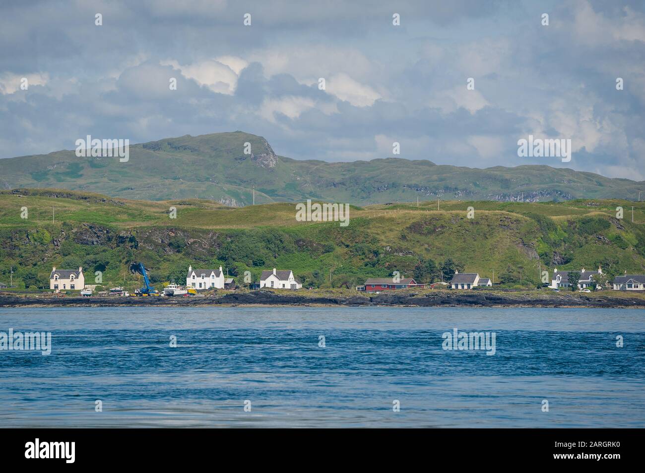 Dorf am Schottland-Ufer Blick vom Wasser. Typische ländliche Landschaft der Hebrideninseln. Stockfoto