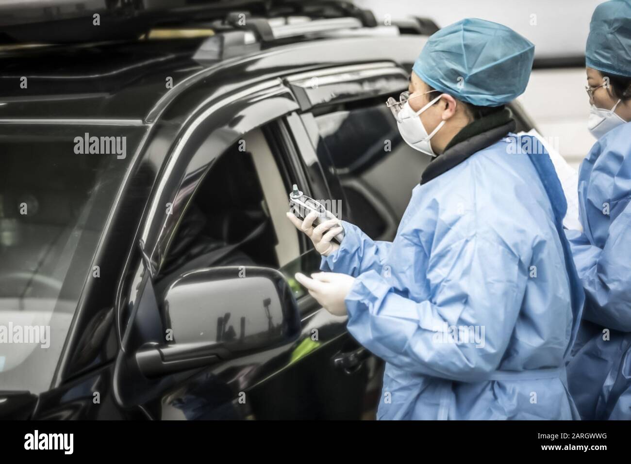 Shanghai, China. Januar 2020. Ein maskierter Gesundheitsfachmann und Polizeibeamte überprüfen den Fahrer eines Fahrzeugs an einem Kontrollpunkt auf einer Mautstation auf der Autobahn am Stadtrand von Shanghai. Regierungen, globale Unternehmen und internationale Gesundheitsorganisationen stürzten auf die Verbreitung eines SARS-ähnlichen Coronavirus, das mehr als 100 Leben in China forderte, Credit: Qilai Shen / Alamy Live News Stockfoto