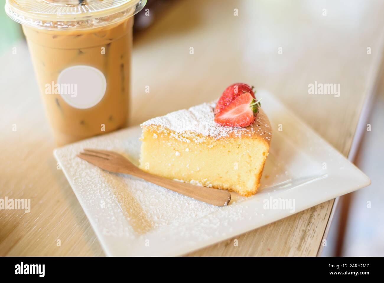 Weicher Kuchen mit Stawberry und Eiskaffe auf dem Tisch Stockfoto