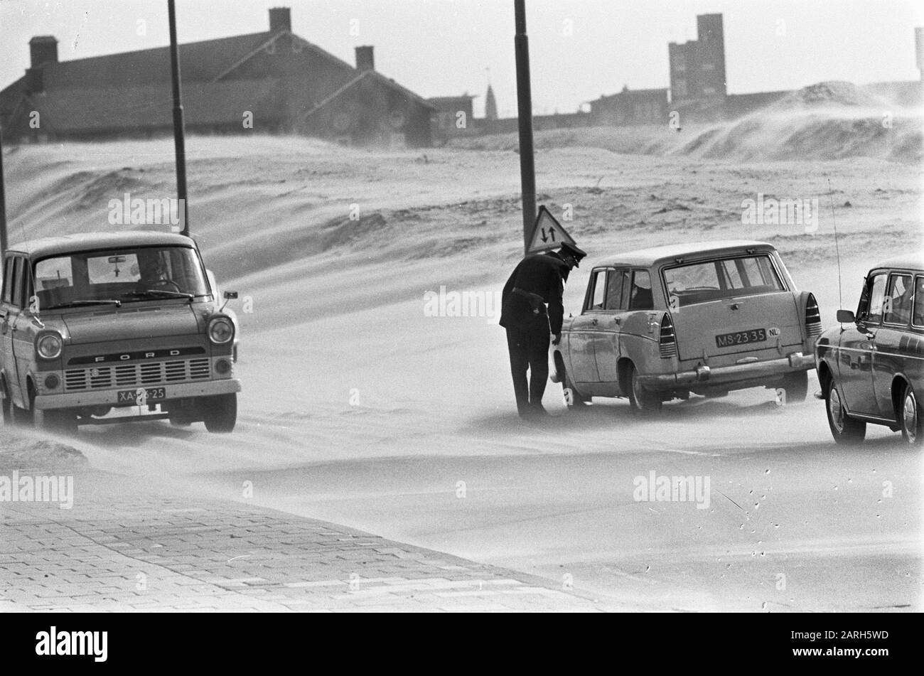 Windkracht 9 in Amsterdam. Fußgänger im Sandsturm Datum: 18. März 1968 Standort: Amsterdam, Noord-Holland Schlagwörter: Fußgänger, Winde, Unwetter Stockfoto