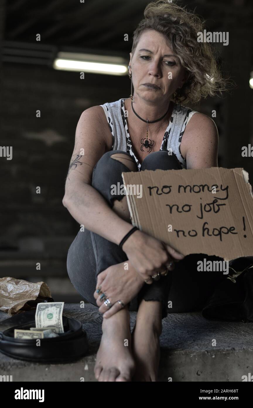 Eine obdachlose Punkfrau bettelte und hielt ein Zeichen - kein Geld, kein Job, keine Hoffnung Stockfoto