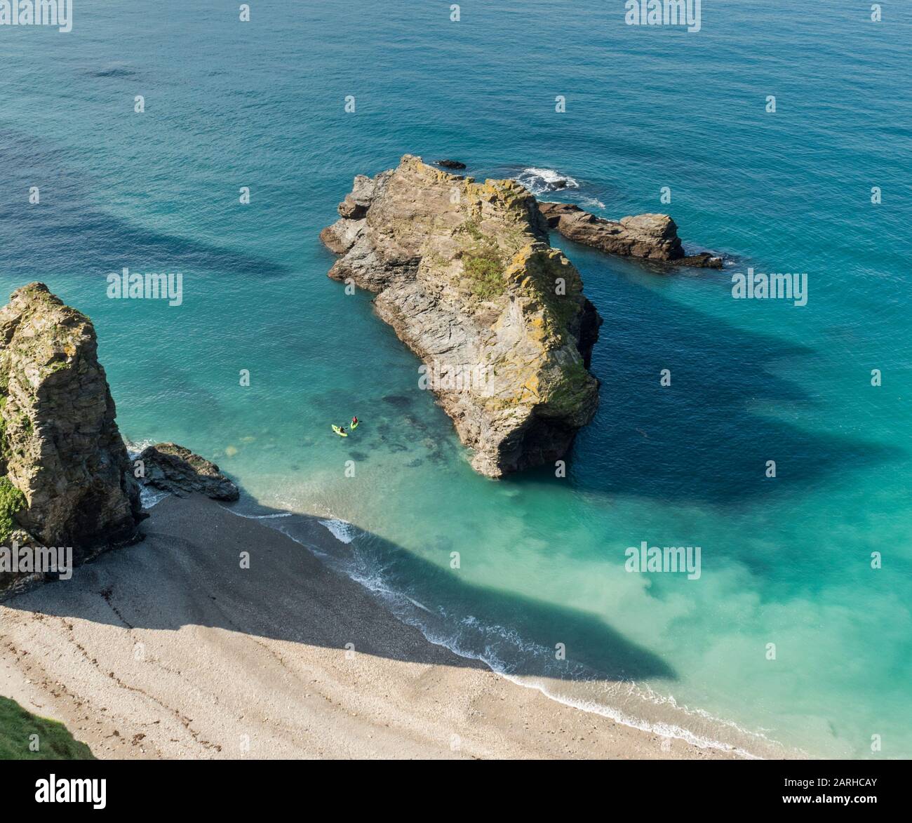 Zwei Kajakfahrer erkunden die Küstenmerkmale in der Nähe von Portreath, Cornwall, vom Clifftop-Pfad oben aus gesehen. Stockfoto